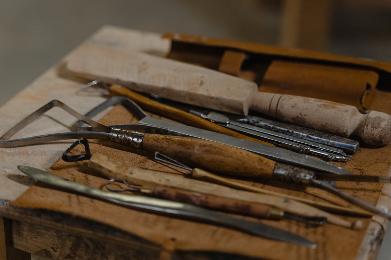A collection of artisan tools arranged on a workshop table, showcasing craftsmanship.